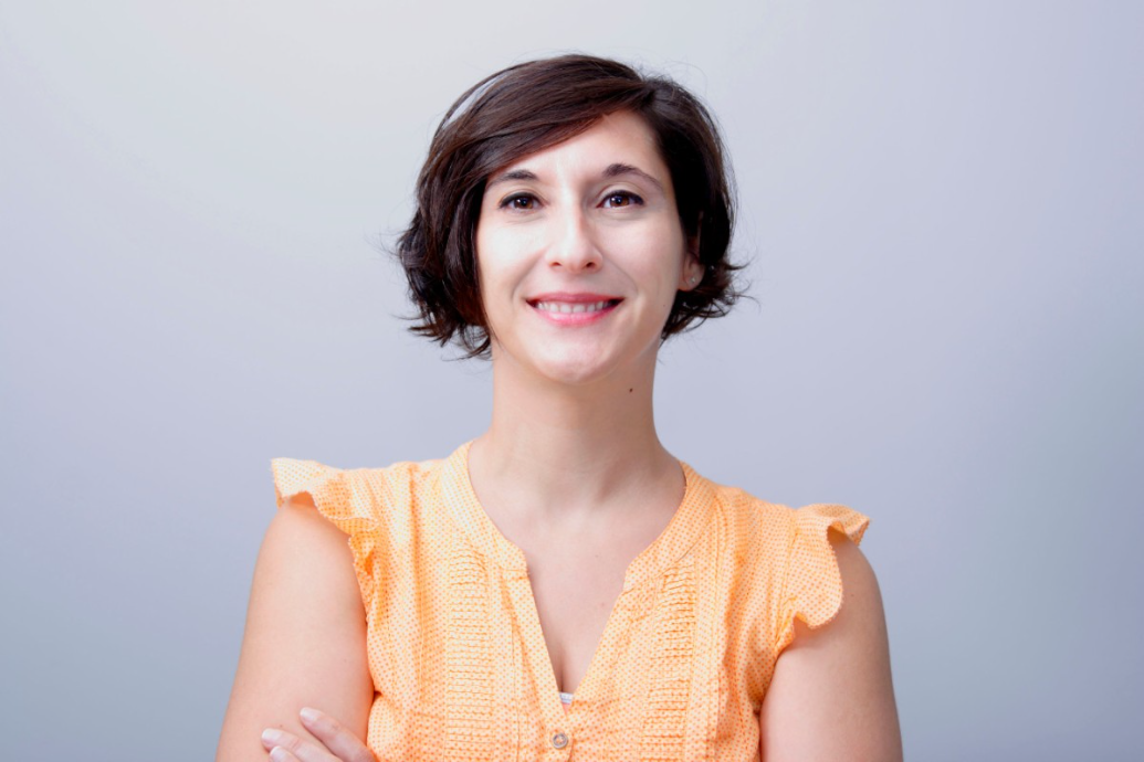 photo-portrait of a smiling woman with dark hair in an orange shirt